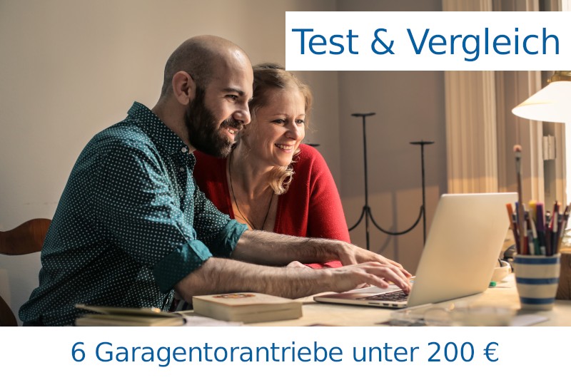 2 Personen sitzen von einem Laptop. Das Bild trägt die Beschriftungen "Test & Vergleich" und "6 Garagentorantriebe unter 200 €"